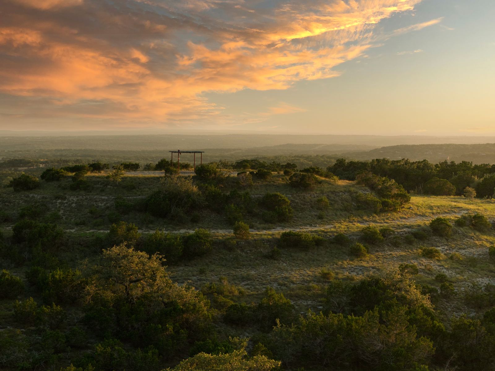 Sunset across Lone Woman Mountain and the long-range Hill Country views at RanchesAt Driftwood
